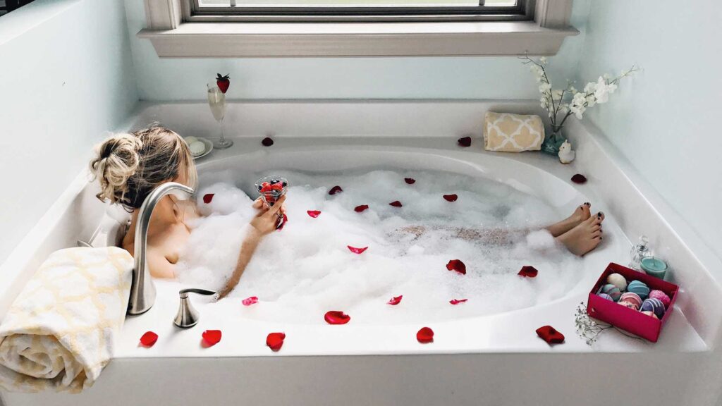 woman with fruits in glass bathing in tub.