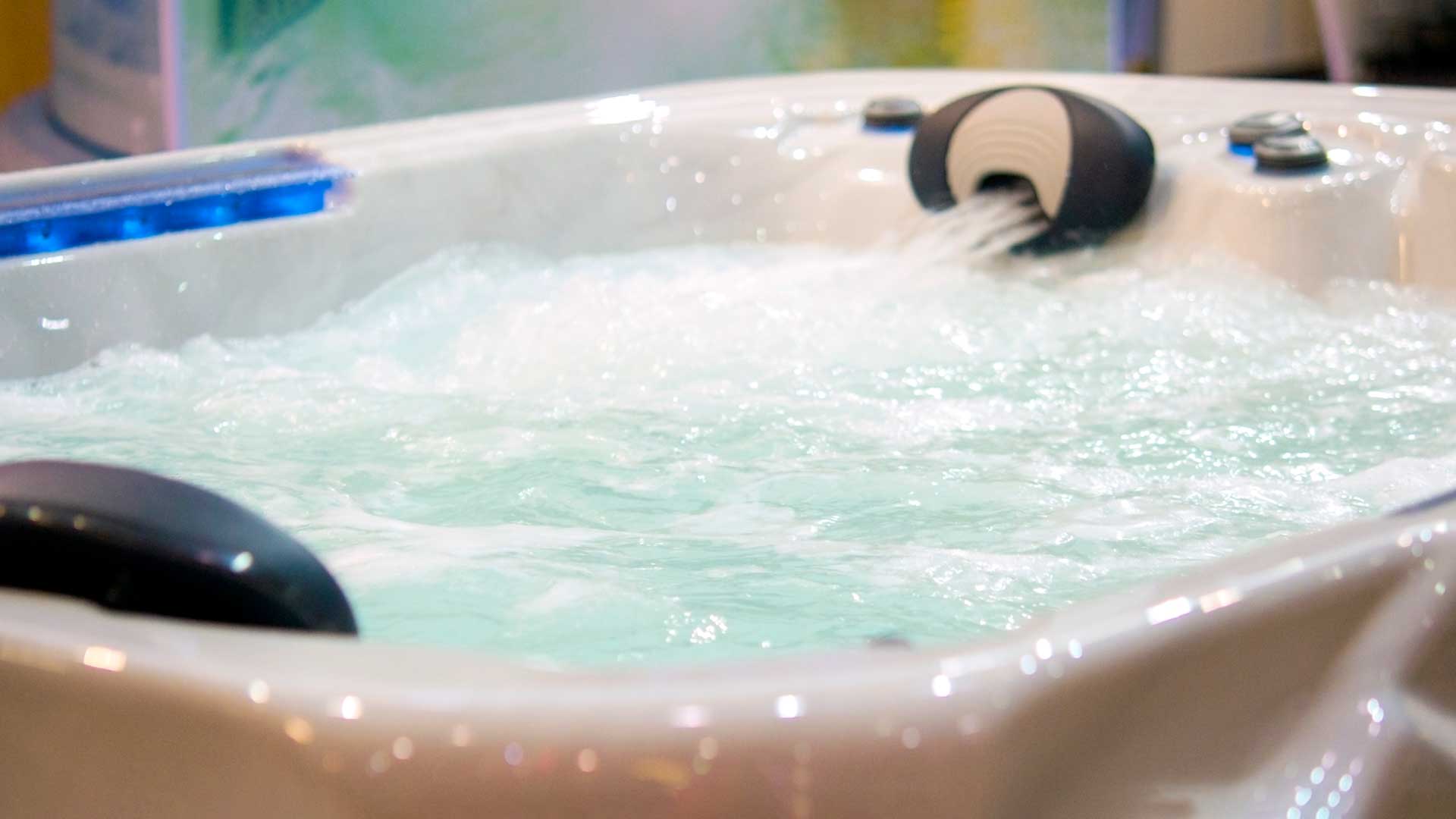 Bathtub filled with water with a waterfall.