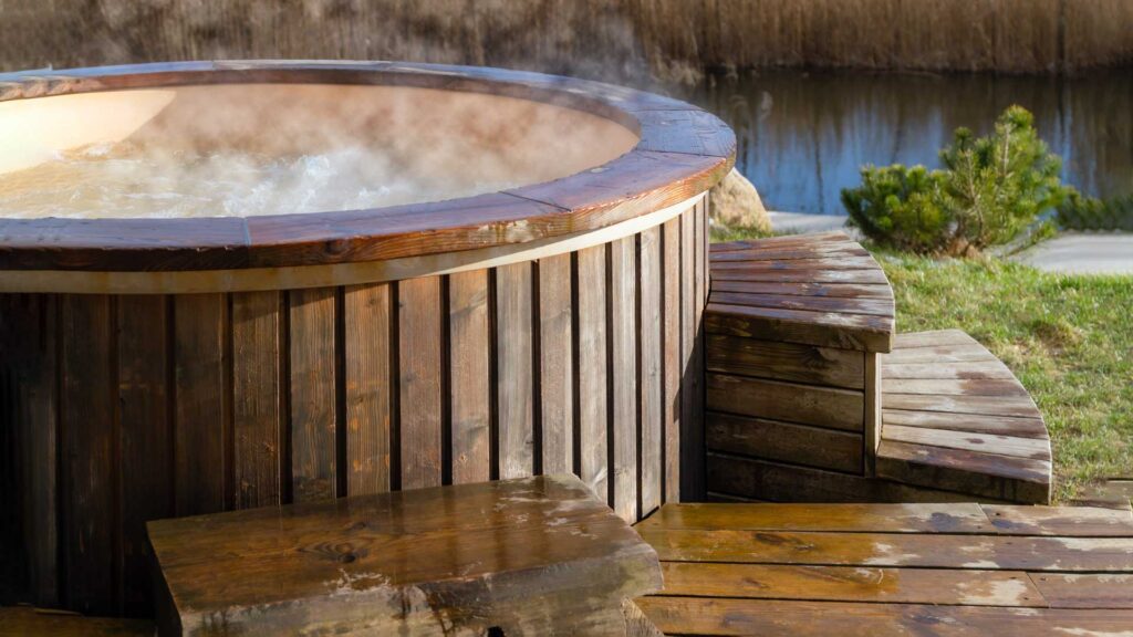 wooden hot tub with steam in forest.