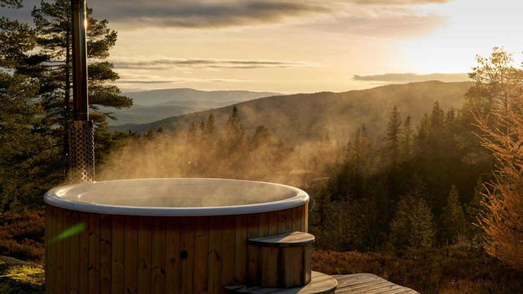 wooden hot tub outside in forest.