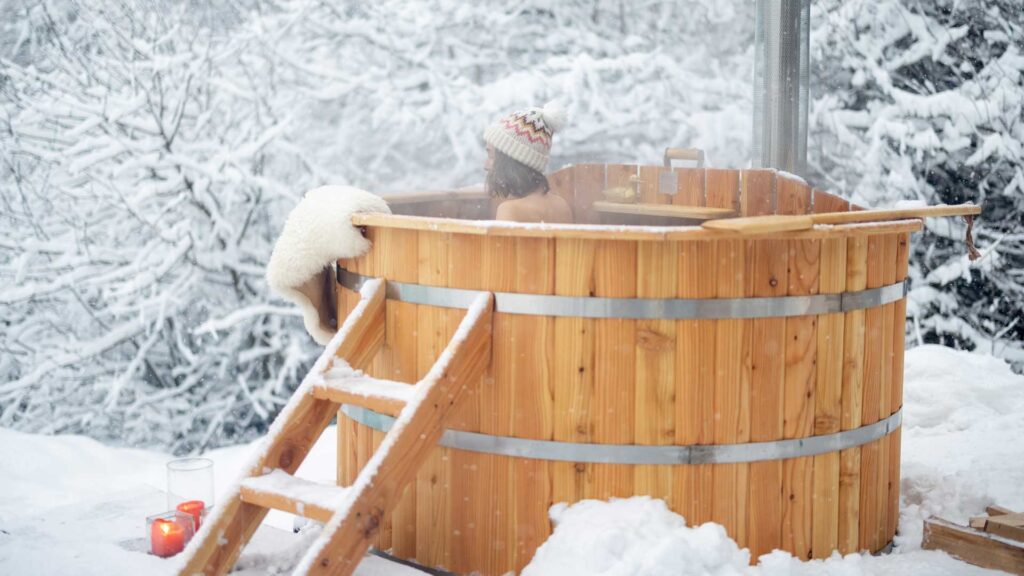young girl soaking wooden tub in winter view.