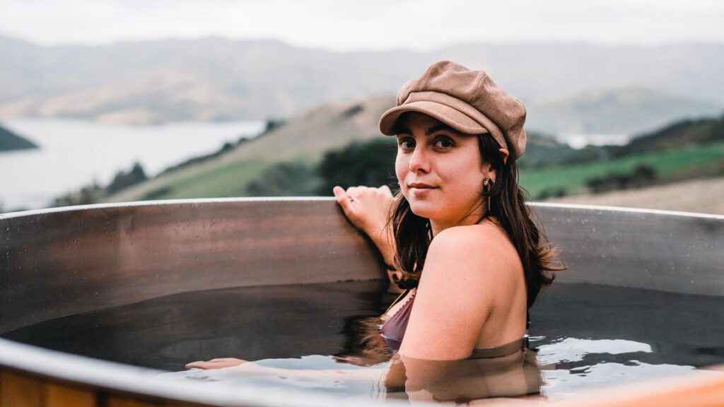 woman wearing hat in outdoor hot tub preventing herself from dehydration