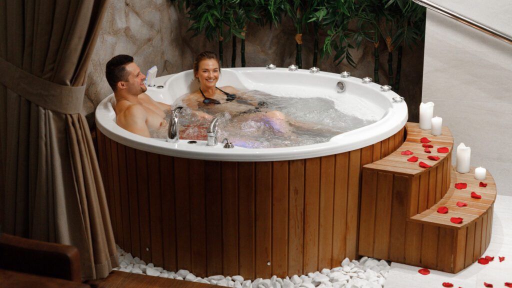 couple taking bath in hot tub placed indoor